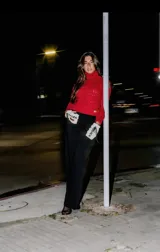 Sweater tejido en lana merino color carmesí, con hombro descubierto y tira delgada ajustable con hebilla metálica.