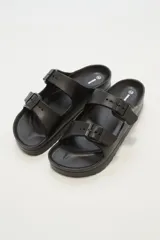 Sandalias de goma color negro con hebillas ajustables.