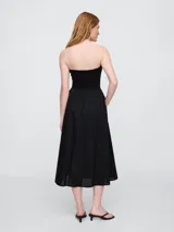 Vestido midi strapless color negro, con elástico en el busto y falda amplia.