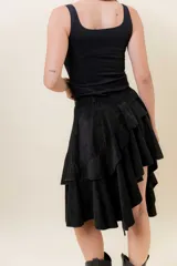 Pollera corta asimétrica de gamuza color marrón, con volados superpuestos y cintura elastizada. Incluye short interno.