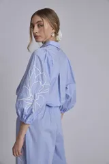 Camisa azul marino con bordados de flores blancas en mangas y falda.