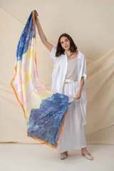 Pañuelo rectangular de seda con estampado abstracto en degrade de colores blanco, gris y naranja, con borde naranja.