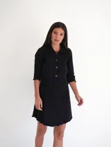 Vestido camisero verde seco de corte holgado, con cuello camisero, mangas 3/4 y cierre frontal con botones.