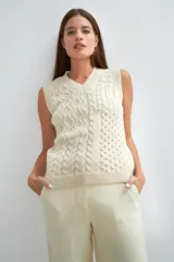 Chaleco tejido marrón con escote en v y sisas amplias. Diseño con diferentes puntos combinados en el frente.