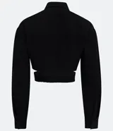 Camisa cropped negra de viscosa con cuello camisero, manga larga con puños abotonados, bolsillos de parche en el pecho, cierre frontal con botones ocultos, recortes laterales y elástico en la espalda.