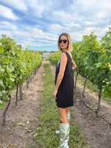 Vestido corto negro de gabardina con corte suelto y escote en V en frente y espalda. La parte delantera está adornada con flecos de lentejuelas plateadas.