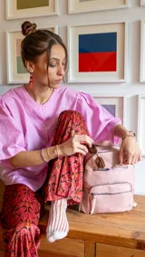 Mochila color beige de tafeta con doble apertura superior con cierre y tiradores metálicos. Incluye bolsillos internos, tres bolsillos con cierre metálico al frente y uno posterior. Asa corta de mano y correas para la espalda regulables.