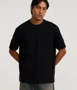 Remera masculina de algodón y poliéster, color negro, con cuello redondo, manga corta y textura de mini waffle. Presenta un corte relajado (relaxed fit).
