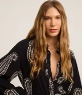 Vestido chemise midi de viscosa con estampado paisley, cuello inglés, manga larga y abotonado delantero.
