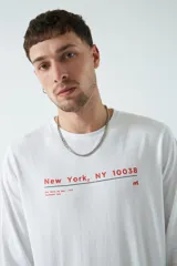Remera celeste de manga larga con cuello redondo y estampado frontal con texto "New York NY 10038"