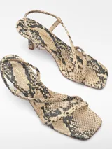 Sandalias de tacón con estampado de serpiente, puntera cuadrada y tiras finas. Fabricadas en Portugal con piel responsable.