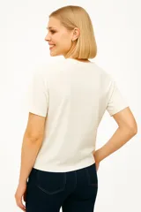 Remera blanca de algodón con estampado de flores en un jarrón.