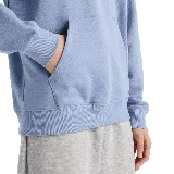 Buzo hoodie celeste con logo de New Balance estampado en blanco en el pecho y bolsillo tipo canguro.