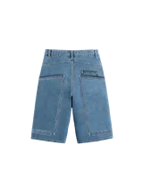 Bermuda de jean azul de corte amplio, con costuras expuestas en delantero y trasero, y bolsillos traseros grandes.