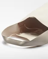 Bolso tipo tote color crudo, con correa de hombro ancha y bolsillo interno con cierre.