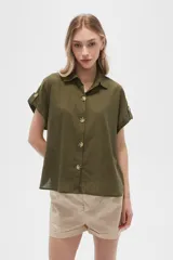 Camisa color verde militar de algodón, con cuello clásico, cierre frontal con botones de carey y mangas cortas con trabilla y botón.