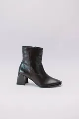 Botas plateadas de cuero con caña media, cierre lateral con cremallera y tacón geométrico.