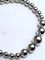 Collar plateado con esferas de diferentes tamaños y cierre de mosquetón con cadena de alargue.