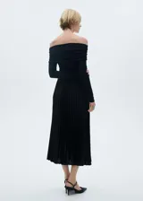 Falda midi plisada color negro, de tiro alto y corte evasé.