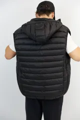 Chaleco puffer negro de nylon con capucha desmontable y cierre frontal.