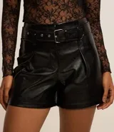 Short negro de cuero sintético con cinturón con hebilla metálica.