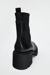 Botín Chelsea negro de cuero con caña de neopreno, tacón bloque y suela track.