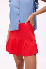 Falda corta de lino color rojo, con diseño de tiro alto y un volado en el ruedo. Posee cierre en la parte posterior.