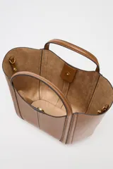 Bolso mini city color marrón con asa de mano y asa bandolera extraíble. Detalle de pespuntes en contraste y bolsa interior extraíble con cierre mediante cremallera.