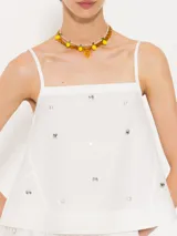 Top blanco de poplin con breteles finitos y piedras al tono en delantero y espalda. Breteles, escote y aberturas laterales terminadas con satén al tono. Cierre invisible lateral.