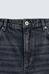 Pantalón de jean de tiro medio, color gris oscuro con efecto lavado, corte ajustado en la parte superior y acampanado desde la rodilla, con cinco bolsillos y cierre frontal con cremallera y botón.