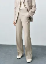 Pantalón de vestir color beige de corte palazzo, tiro medio y tejido ligero.