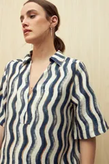 Vestido corto con estampado de rayas onduladas en blanco y azul, cuello tipo solapa y escote en V.