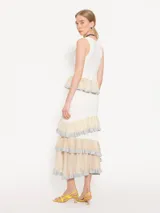 Falda midi de color blanco con paneles horizontales en beige y volados con borde plateado.