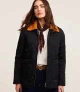Campera puffer negra con cuello de terciopelo color mostaza, cierre frontal con cremallera y bolsillos laterales.