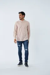 Camisa de hombre color rosa claro con cuello mao y mangas largas. Confeccionada en algodón con apariencia de lino y cierre abotonado. El modelo usa talle M.