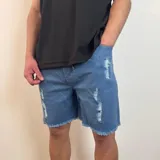 Bermuda de jean color negro con efecto desgastado y roturas, corte jogger arriba de la rodilla y cintura con cordón ajustable.