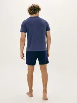 Pijama de dos piezas compuesto por remera manga corta gris con cuello en V y bordado de logo en el pecho, y short negro.