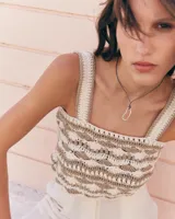 Collar con dije irregular dorado y cordón marrón ajustable.