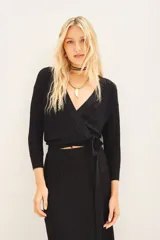 Cardigan crop negro tejido en punto desagujado con lurex, escote V cruzado y ajuste en la cintura.