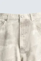 Pantalón de jean blanco, corte holgado y amplio en toda la pierna, tiro medio, tejido ligero, cinco bolsillos, efecto lavado y cierre frontal con cremallera y botón.