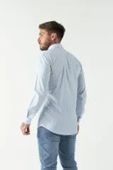Camisa celeste a cuadros, de corte slim fit, manga larga y logo bordado. Confeccionada en 100% algodón.