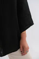 Blusa negra de lino con cuello camisero, manga 3/4 y un botón.