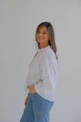 Camisa blanca de mangas largas con bordado de flores y cuello mao.