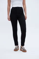 Pantalón de jean negro de tiro medio con calce ajustado desde la cintura hasta los tobillos.