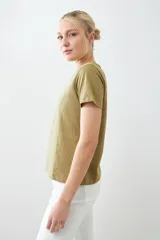 Remera verde oliva de manga corta con cuello en V y estampado floral en relieve.