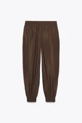 Pantalón de jogging color marrón, de tiro medio con cintura elástica ajustable con cordones, bolsillos delanteros y puños elásticos en los tobillos.