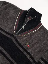 Sweater azul con cuello alto con medio cierre, textura tipo terciopelo y puños acanalados.