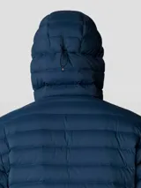 Campera negra con capucha, rellena de plumón de 650 cuins. Confeccionada en tejido Pertex® Quantum resistente al agua. Cuenta con cierre frontal, bolsillos laterales con cierre y un bolsillo en el pecho con cierre. Se puede guardar en su propio bolsillo.