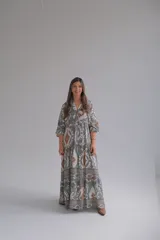 Vestido largo de corte amplio con estampado geométrico en tonos grises, marrones y blancos. Tiene cuello en V y mangas 3/4.