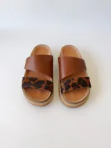 Sandalias bajas de cuero marrón con estampado animal print en las tiras.